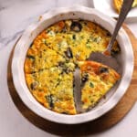 An overhead image of crustless quiche with a serving spoon.