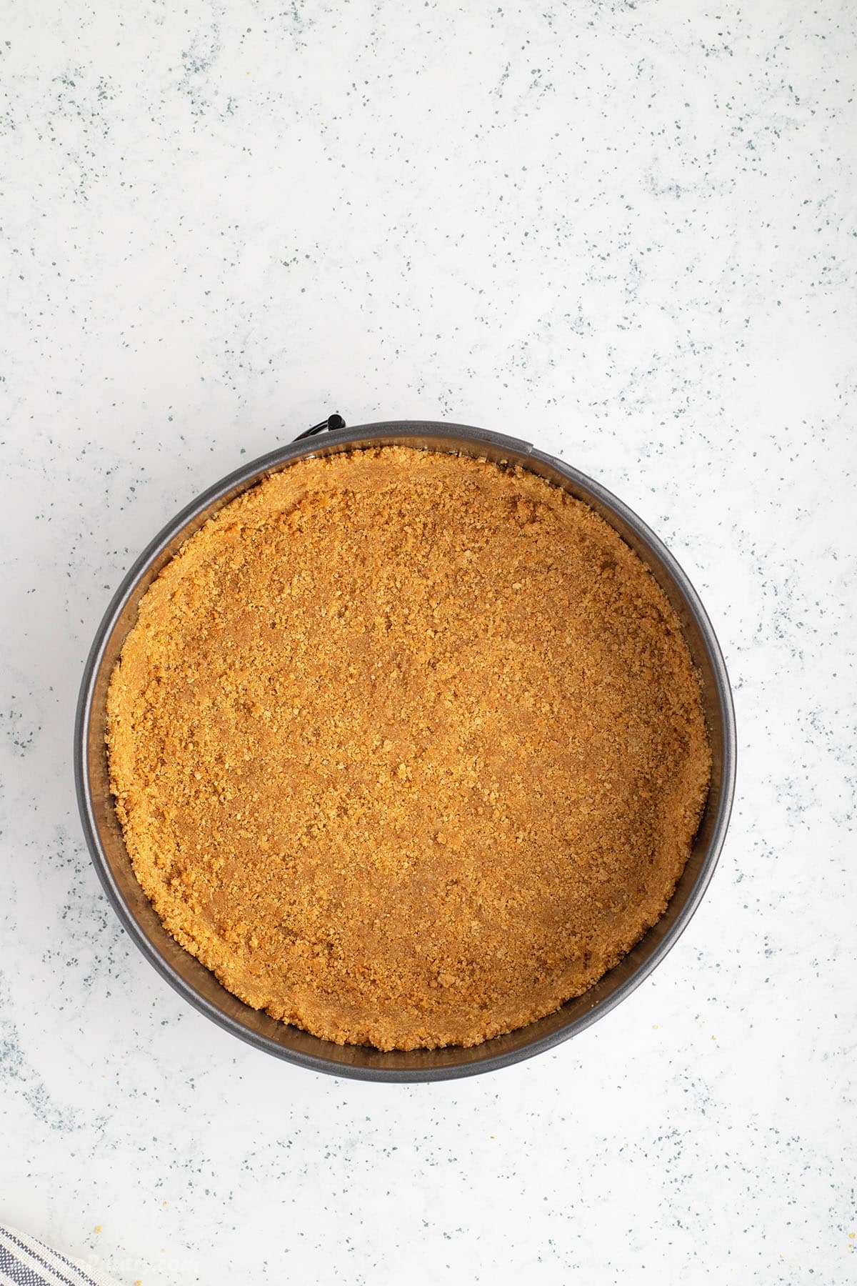 Graham crackers pie crust in a spring foam pan.