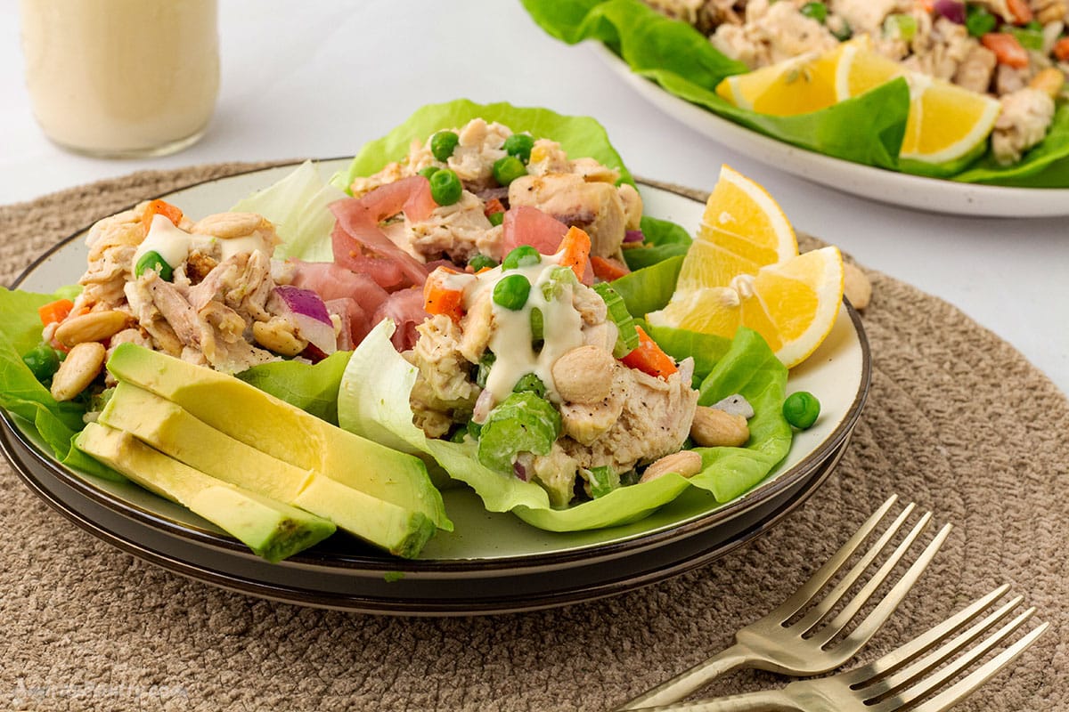 Chicken salad on a small salad plate with sliced avocados.