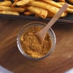 An overhead image of a glass bowl with fries seasoning.