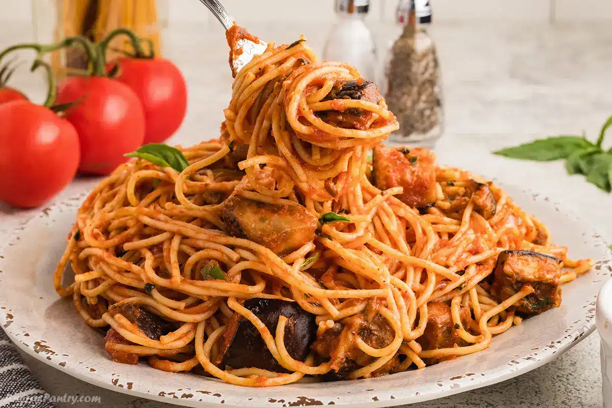 A close up image of a plate with a fork with some pasta.