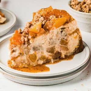 A slice of peach cheesecake on a dessert plate.