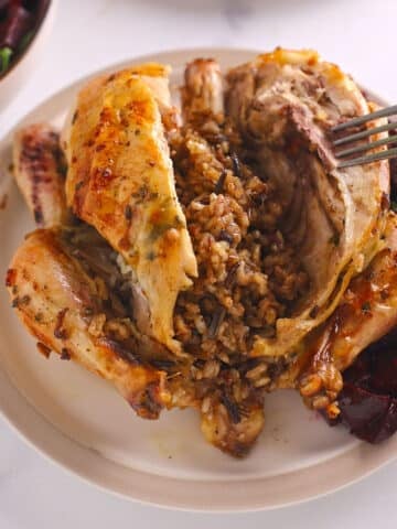 An overhead image of a cornish hen cut from the middle to show rice inside.