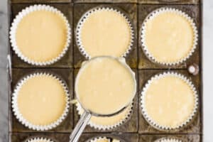 Scooping cupcake batter into cupcake tin.