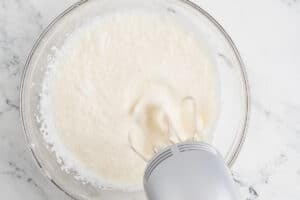 Whipping the cream in a glass bowl.
