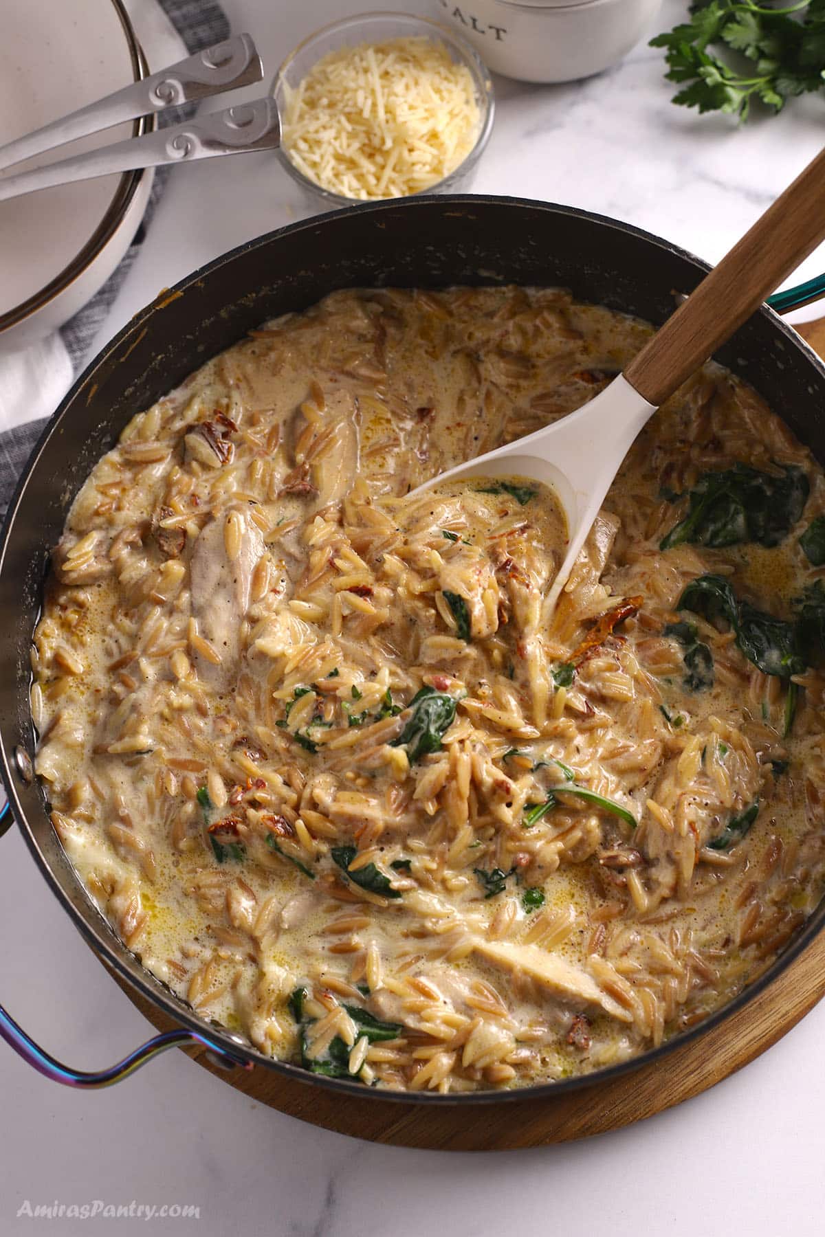 An overhead image of a large skillet with chicken orzo.
