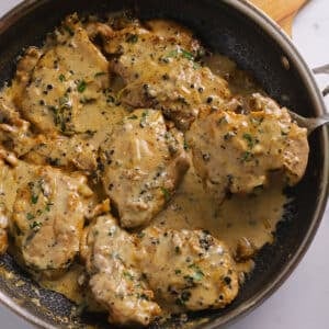 An overhead image of a large skillet with chicken pieces.
