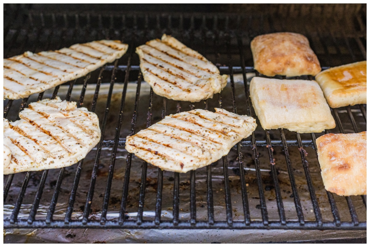 Grilling chicken and bread on an outside grill.
