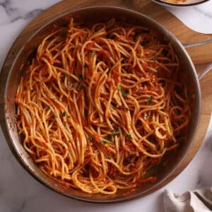 An overhead image of a large skillet with harissa pasta.