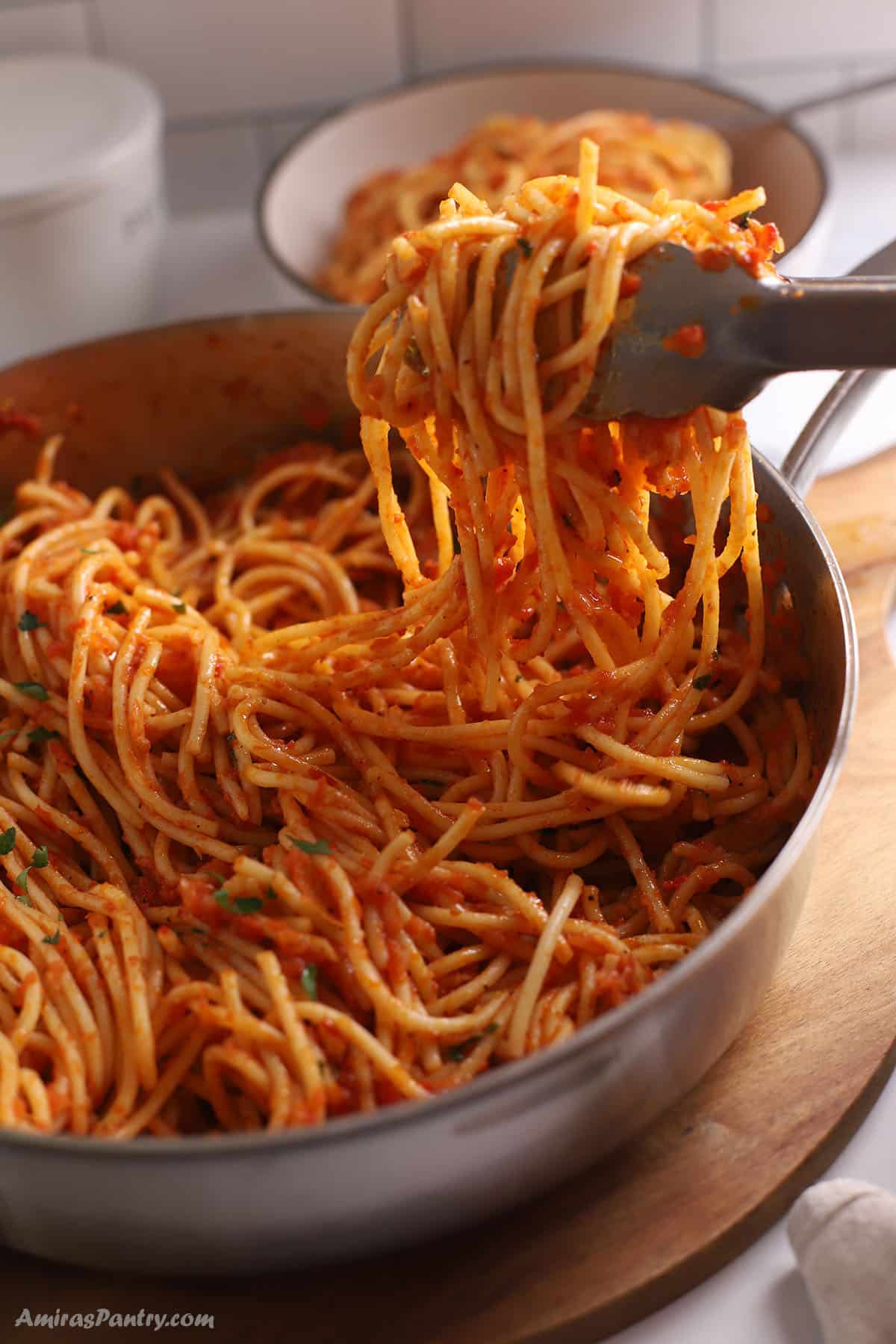 Kitchen tongs with harissa pasta.