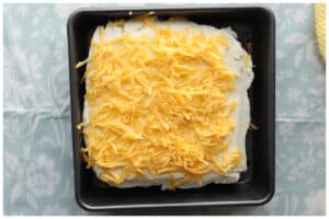 Meatloaf topped with mashed potatoes and shredded cheese.