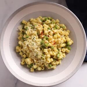 An overhead image of a big bowl with pasta and peas.