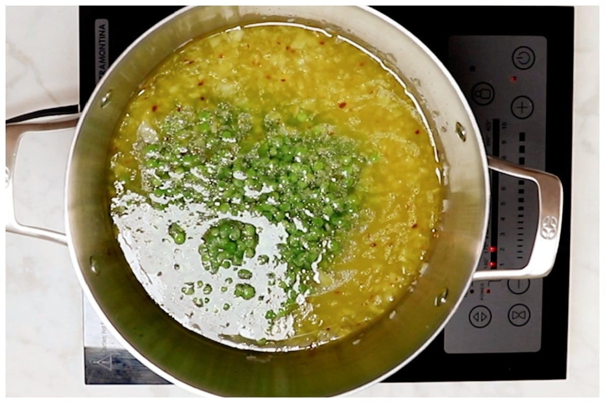 Boiling peas with onions in water.