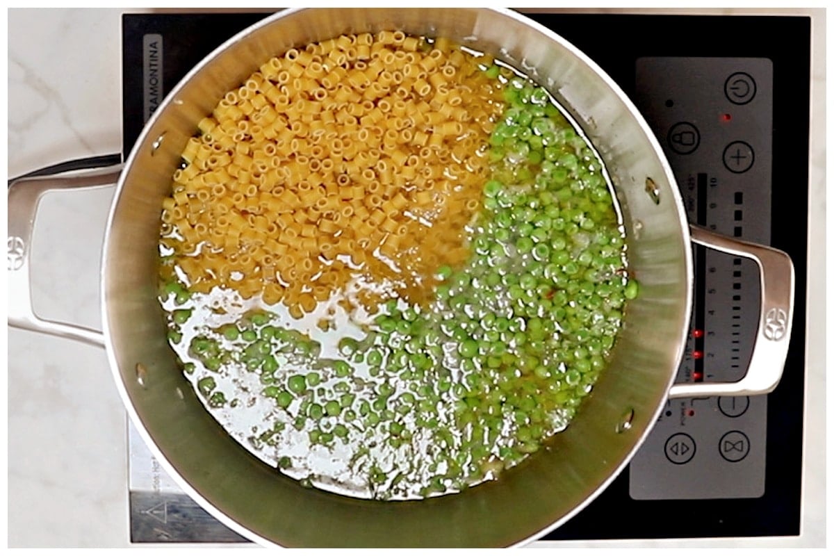 A large pot with pasta and peas.