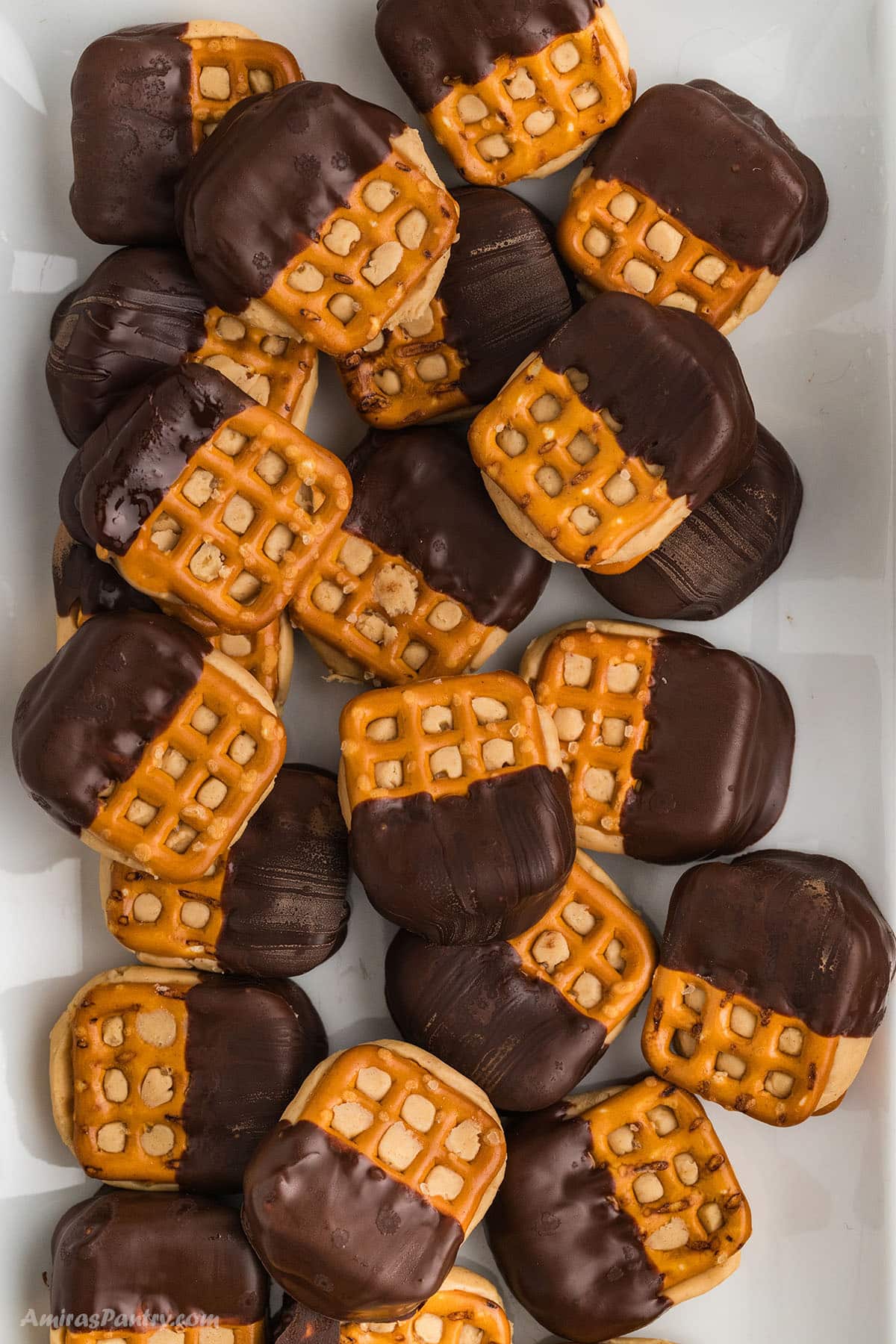 Pretzel bites dipped in chocolate on a serving platter.
