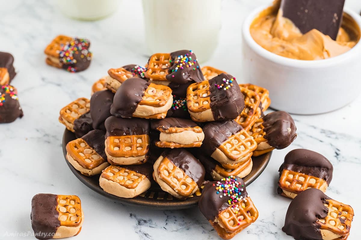 A pile of peanut butter pretzel sandwiches on a serving plate.