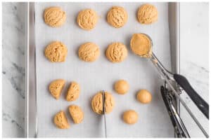 A cookies sheet with peanut butter balls.