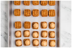 A cookie sheet with peanut butter pretzel sandwiches.