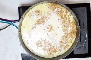 Milk and heavy cream in the skillet with orzo.