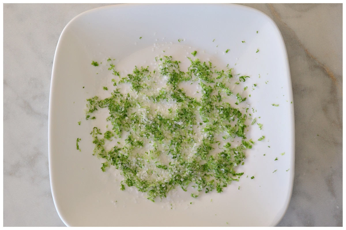 Lime zest and salt mixed on a white plate.