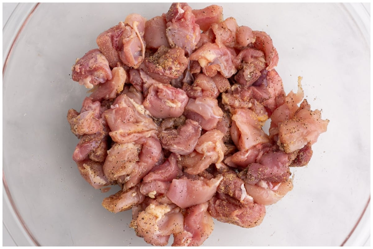 Chicken thighs marinated in a bowl.