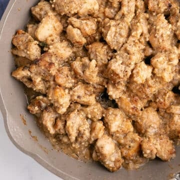 An overhead image of part of a skillet with garlic chicken thighs.