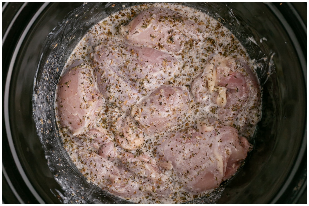 Chicken thighs coated with marinade in the slow cooker.