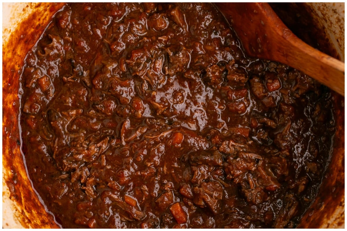 A large pot with shredded beef and sauce.