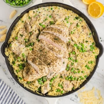 A large skillet with chicken orzo.