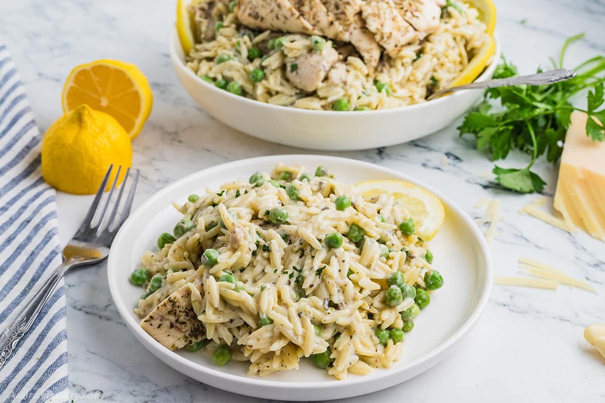 Lemon chicken orzo serving on a white plate.