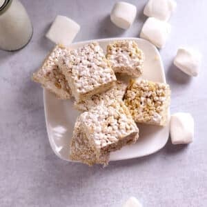 A stack of Rice Krispie treats on a white plate.