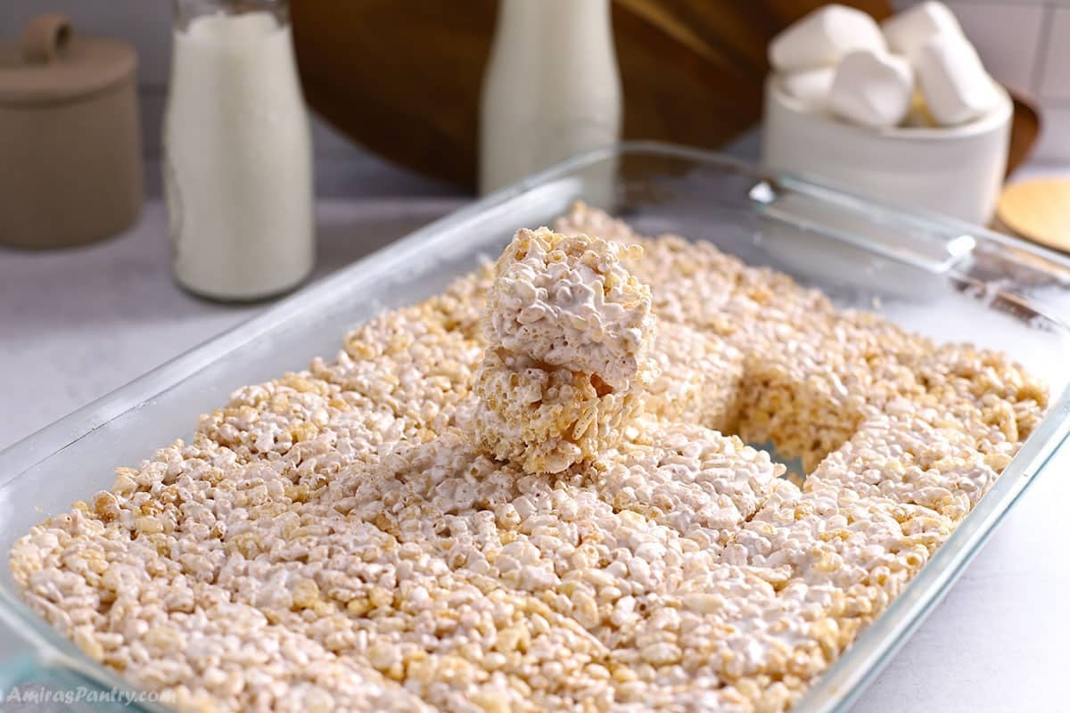 A large pan of rice krispie treats with one taken out.