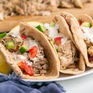 A stack of chicken gyros sandwiches on a platter.