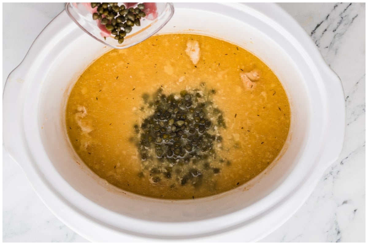 Adding capers to the slow cooker.