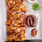 An overhead image of slices of flatbread pizza with bbq sauce.