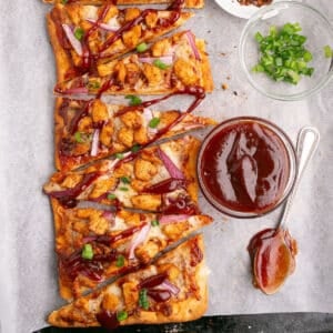 An overhead image of slices of flatbread pizza with bbq sauce.