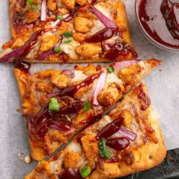 A close up image of slices of chicken flatbread pizza.