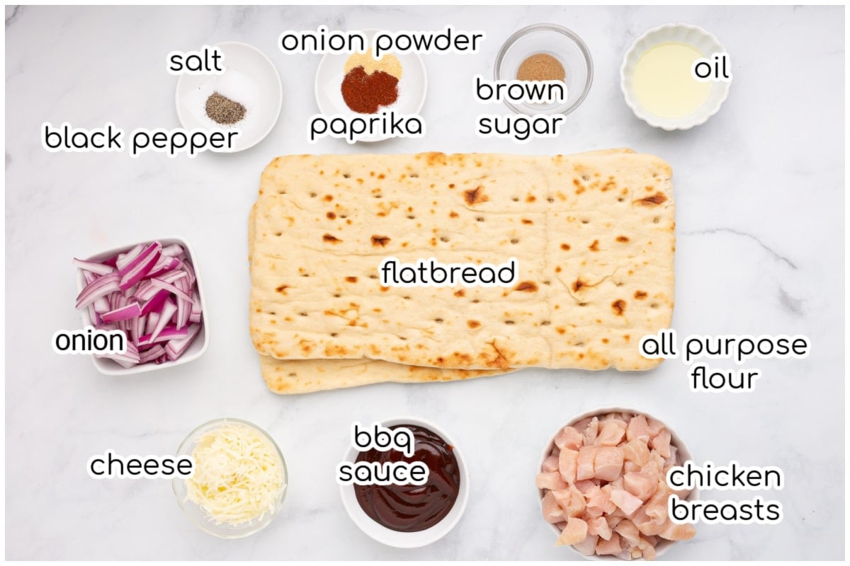 Ingredients for the chicken flatbread pizza on a marble surface.