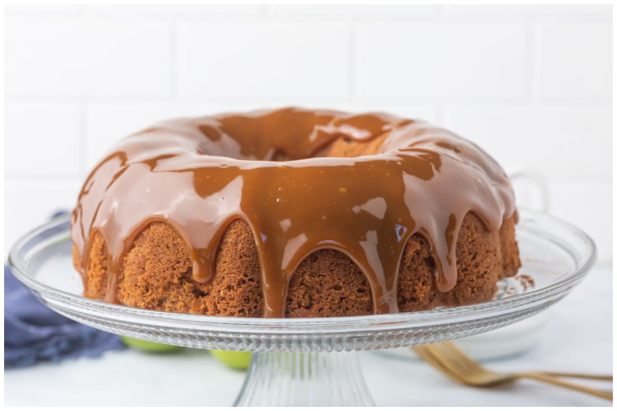 A side view of apple spice cake drizzled with caramel sauce.