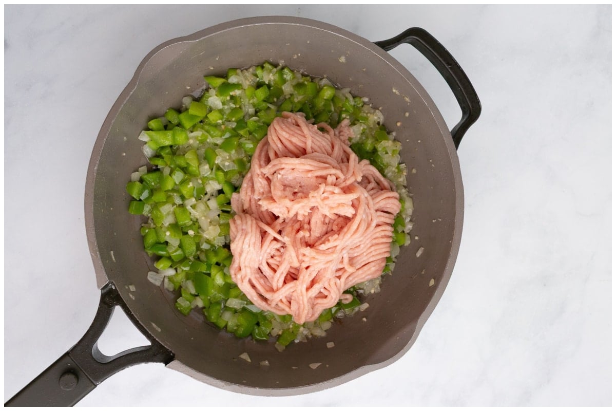 A skillet with added ground chicken.
