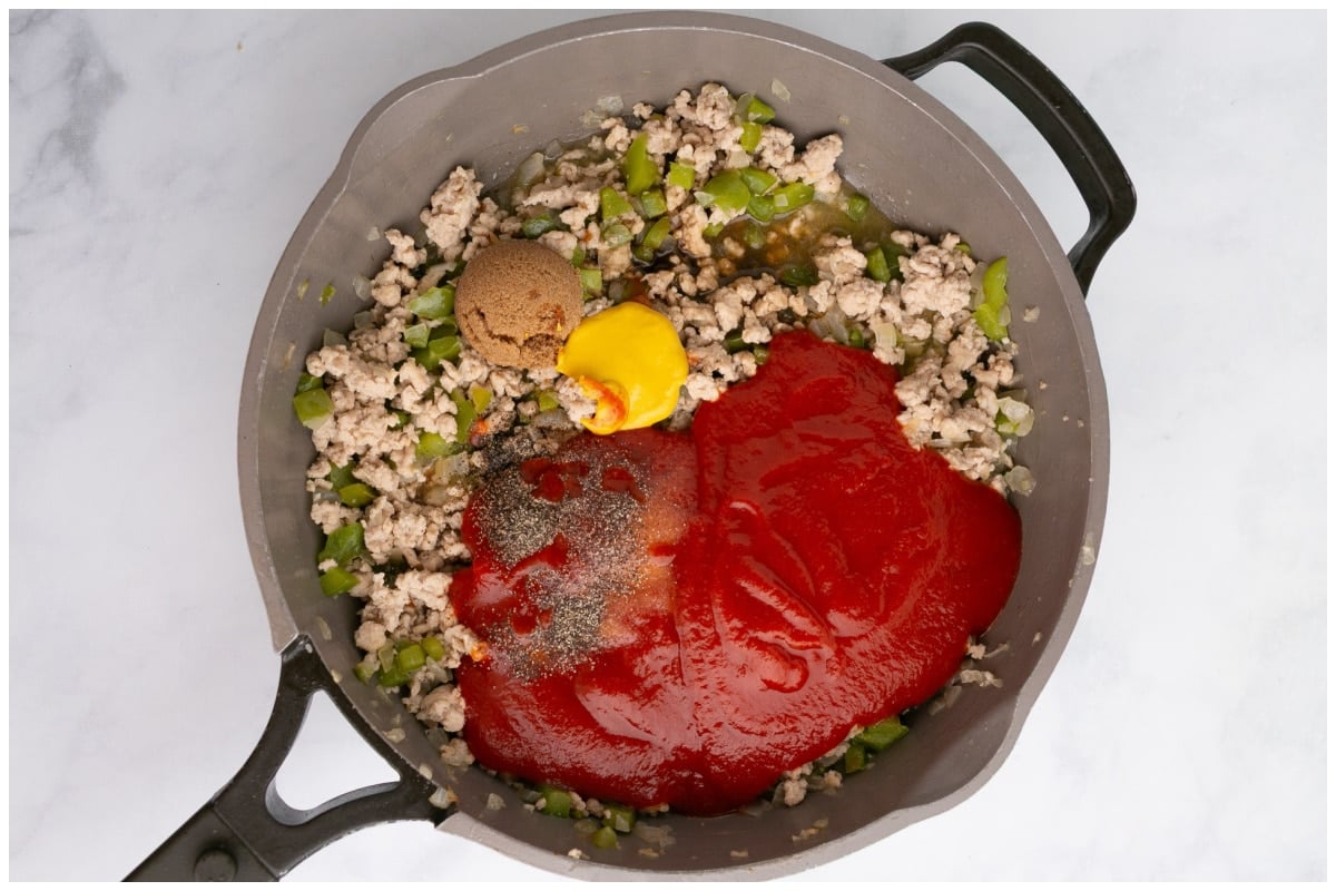A large skillet with sloppy joes ingredients.