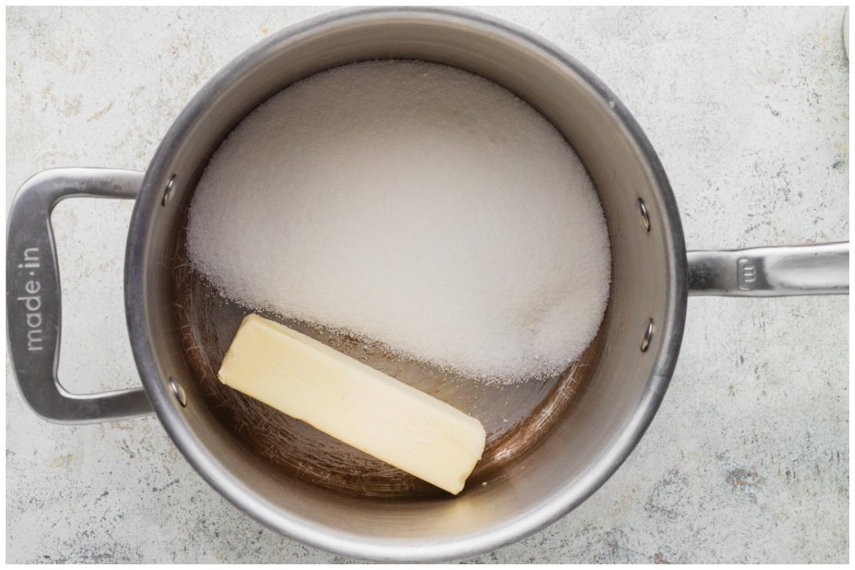 A stainless steel pot with butter and sugar. 