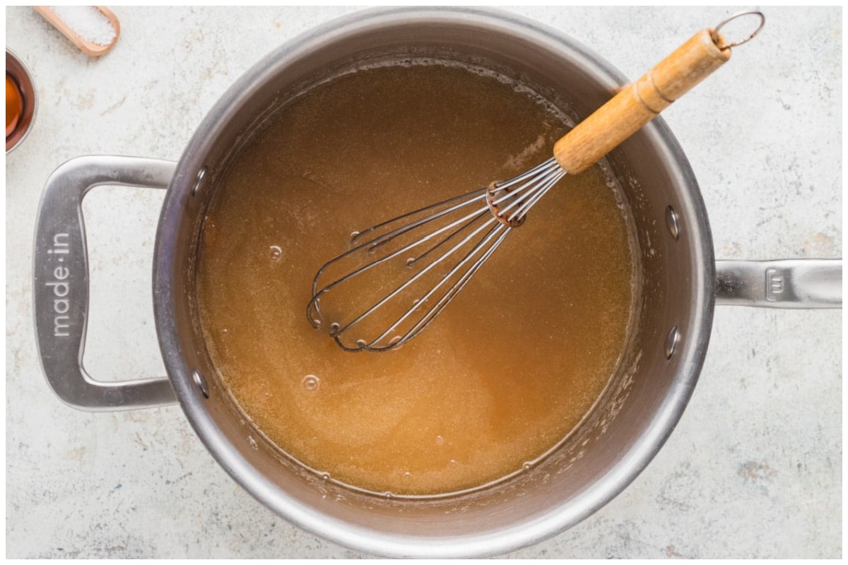 Caramel sauce with a whisk cooking in a sauce pan.