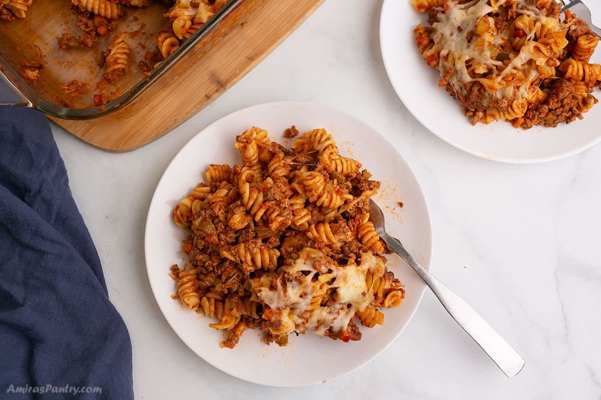 An overhead image of a white plate with pasta bolognese.