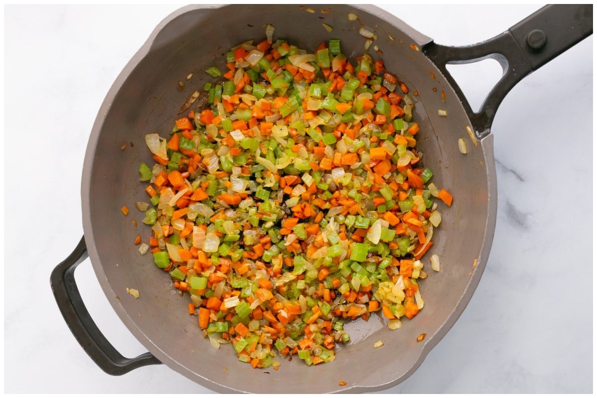 Cooking carrots, celery and onions in a large skillet.