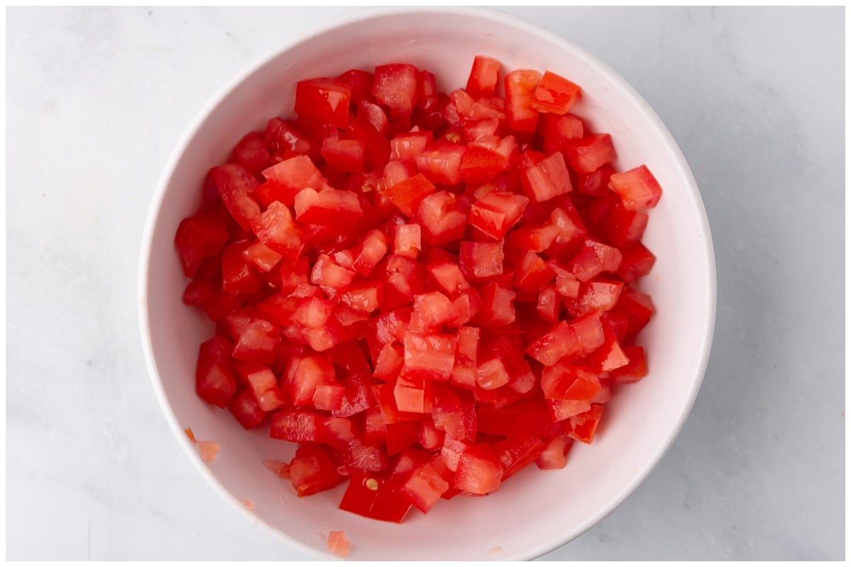 Diced tomatoes in a white bowl.