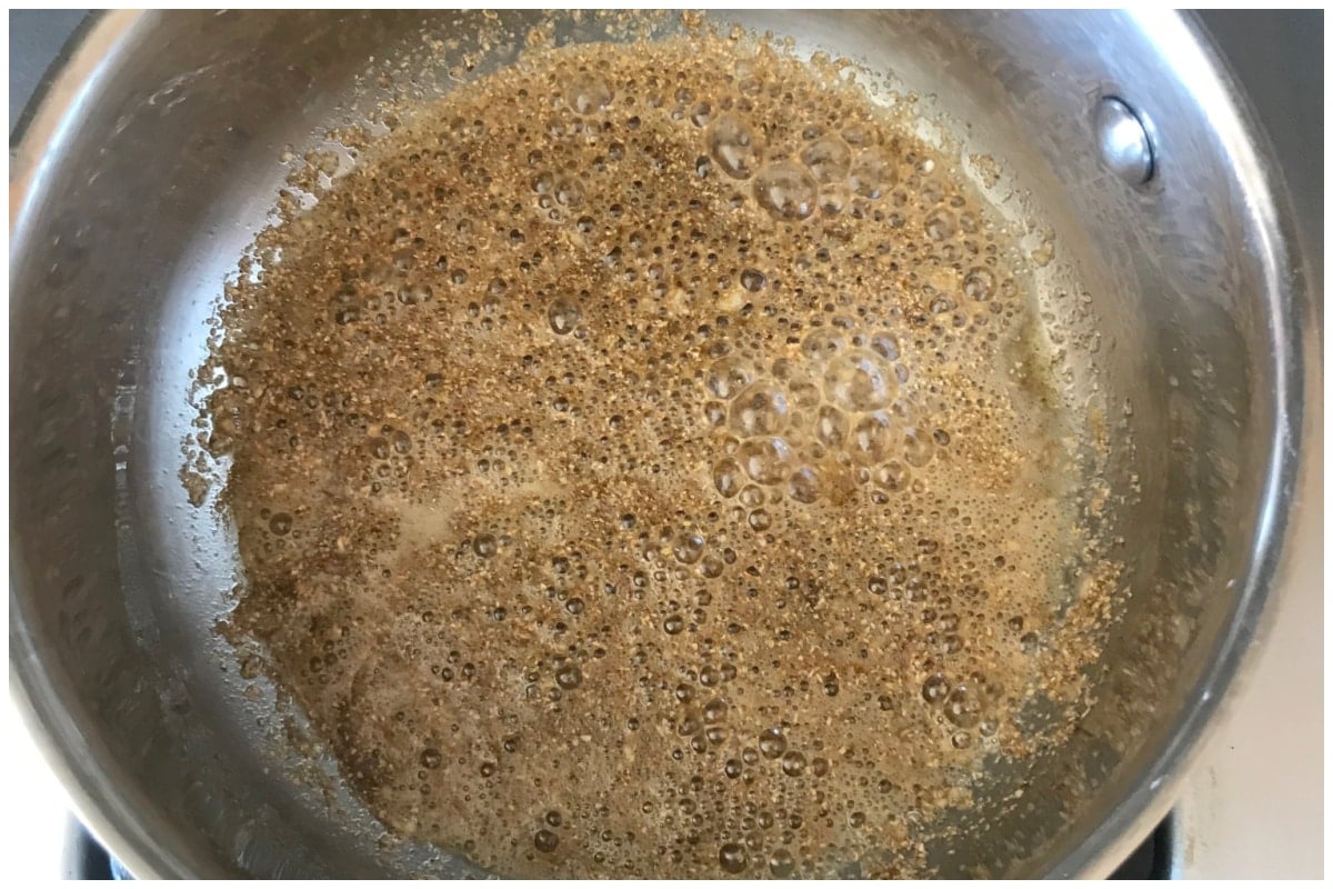 Adding coriander to the saucepan to make molokhia.