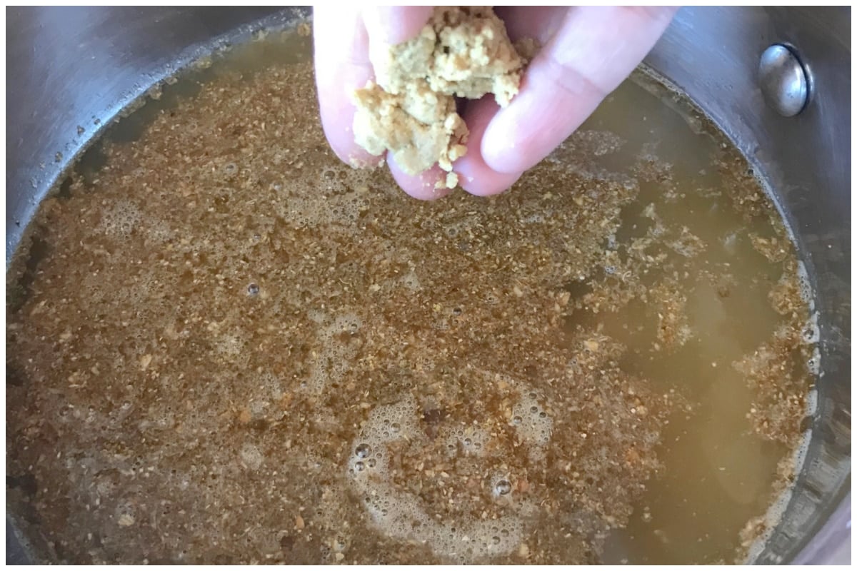 Sprinkling bouillon cube on the soup. 
