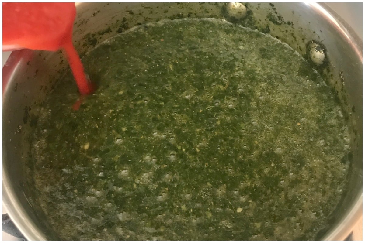 Pouring tomato sauce over the molokhia.