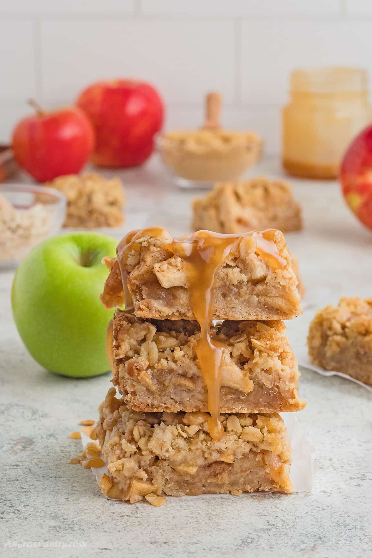 A stack of apple pie bars with salted caramel sauce dripping from the top.